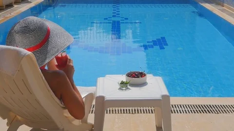Back view of slim young woman relaxing near swimming pool. Stock Footage