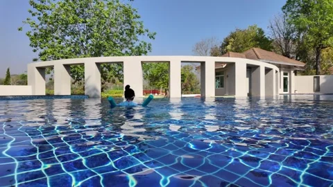 Back view small child in swimming pool. Child on sunny day at swimming pool. Stockbeeldmateriaal 267645147