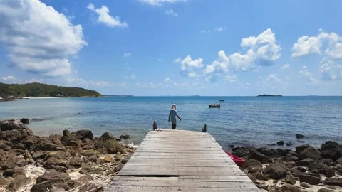 Back view small child walking on wooden dock pier at shore. Stock Footage 274371579
