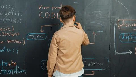 Back view of smart boy writing engineering prompt on blackboard. Erudition. Stock-Fotos