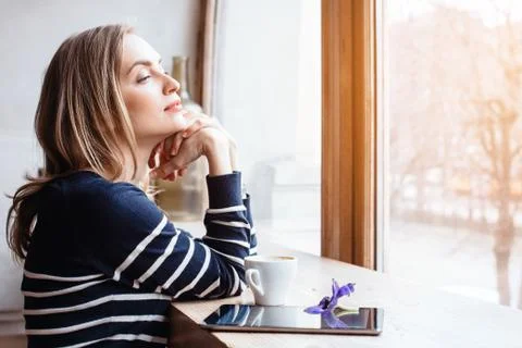 Back view smiling beautiful young woman read magazine with digital tablet near Stock Photos