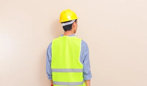 Back view of Southeast Asian construction worker in yellow hard hat and saf.. Stock Photos