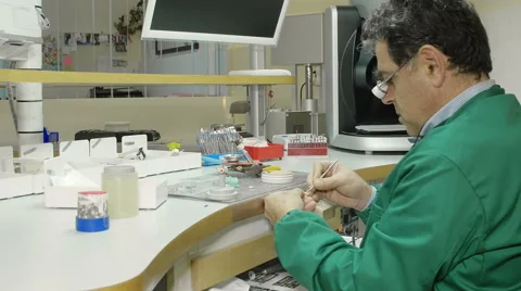 Back view of a specialized techician working at his desk full of tools Stock Footage 59939941