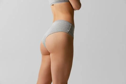 Back view of sportive body, bottocks of young woman in grey bottocks isolated on Stock Photos