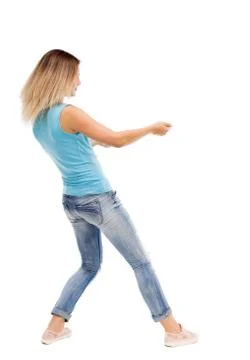Back view of standing girl pulling a rope from the top or cling Foto stock