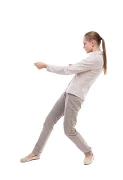 Back view of standing girl pulling a rope from the top or cling Foto stock