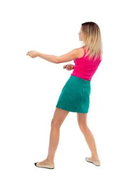 Back view of standing girl pulling a rope from the top or cling Foto stock