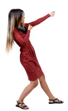 Back view of standing girl pulling a rope from the top or cling Stock Photos