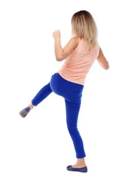 Back view of standing girl pulling a rope from top or cling to s Foto stock