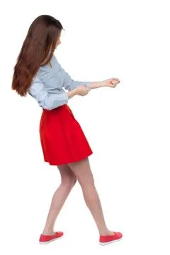 Back view of standing girl pulling a rope from the top or cling Foto stock