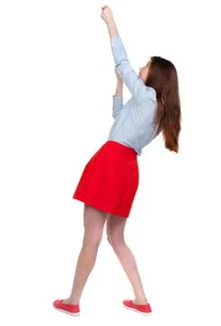 Back view of standing girl pulling a rope from the top or cling Stock-Fotos