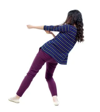 Back view of standing girl pulling a rope from top or cling to s Stock Photos