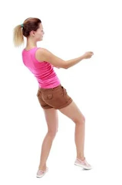 Back view of standing girl pulling a rope from the top or cling Stock Photos