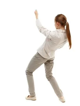 Back view of standing girl pulling a rope from top or cling to s Stock Photos