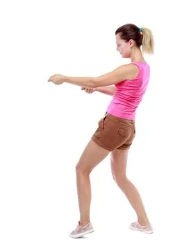 Back view of standing girl pulling a rope from the top or cling Stock-Fotos