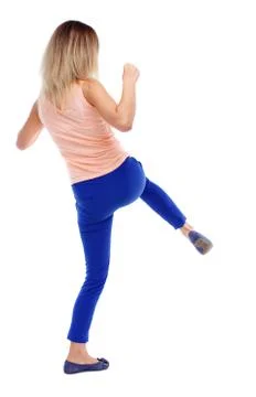 Back view of standing girl pulling a rope from top or cling to s Stock Photos