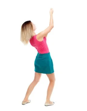 Back view of standing girl pulling a rope from the top or cling Stock Photos