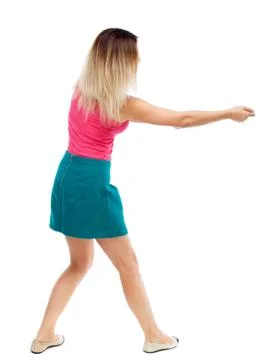 Back view of standing girl pulling a rope from the top or cling Foto stock