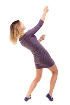 Back view of standing girl pulling a rope from the top or cling to something Stock-Fotos