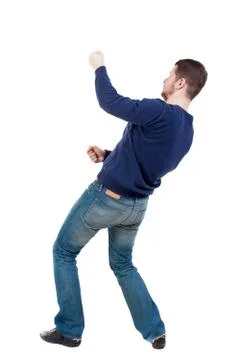 Back view of standing man pulling a rope from the top or cling t Stock Photos