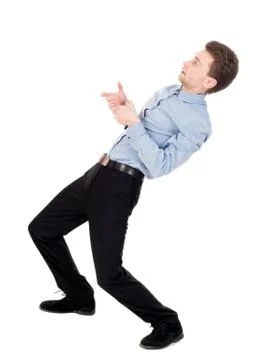 Back view of standing man pulling a rope from the top or cling t Stock Photos