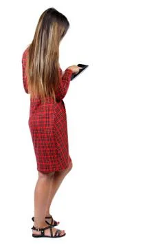 Back view of standing young beautiful  woman  and using a mobile Foto stock