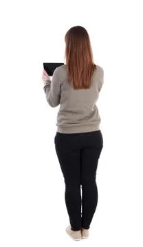 Back view of standing young beautiful  woman  using a mobile pho Foto stock