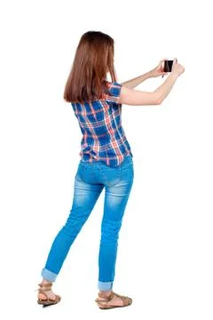 Back view of standing young beautiful  woman  using a mobile pho Stock Photos