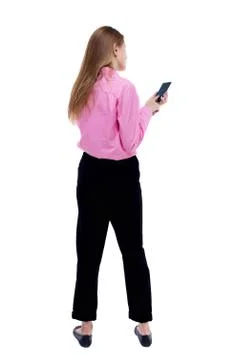 Back view of standing young beautiful  woman  and using a mobile Foto stock