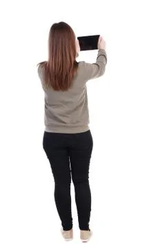 Back view of standing young beautiful  woman  using a mobile pho Stock Photos