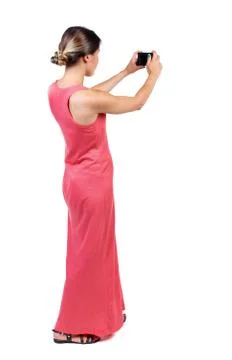 Back view of standing young beautiful  woman using a mobile phon Stock Photos