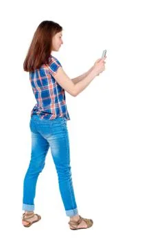 Back view of standing young beautiful  woman  using a mobile pho Stock Photos