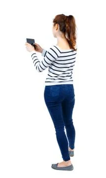Back view of standing young beautiful  woman  using a mobile pho 스톡 사진