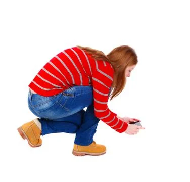 Back view of standing young beautiful  woman  using a mobile pho Stock Photos