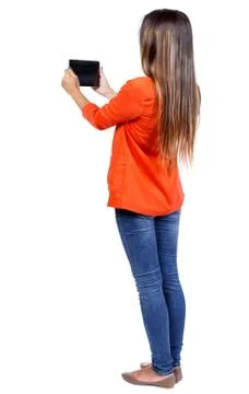 Back view of standing young beautiful  woman  using a mobile pho Stock Photos