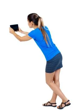 Back view of standing young beautiful  woman  using a mobile pho Stock Photos