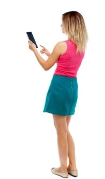 Back view of standing young beautiful  woman using a mobile phon Stock Photos