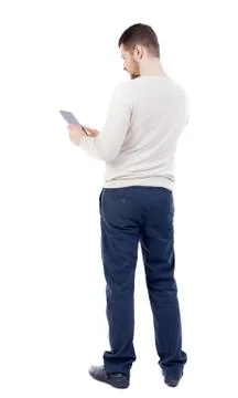 Back view of standing young man with tablet computer in the hand Foto stock