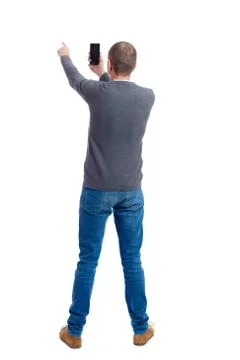 Back view of standing young man and using a mobile phone Stock Photos