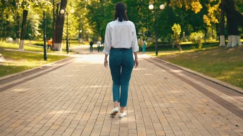 Back view student walks on the street slow motion Stock Footage 127859439