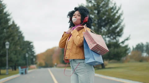 Back view of stylish Afro-American woman turning to camera, blowing bubblegum Stock Footage 255370791