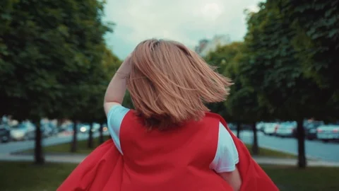 Back view of a stylish red-haired girl in trendy casual outfit walking down the Stock Footage 91452197