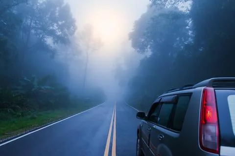 Back view of SUV car on the dark mountain road. Stock Photos