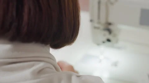 Back View Tailor Folding Cloth On Tacking Machine With Careful Alignment In Stock Footage 307137188
