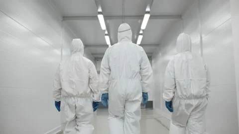 Back view of three disinfectors or doctors walk in protective uniform walking in Stock Footage 143550435