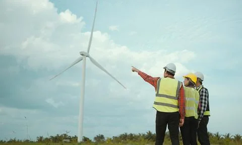 Back view of three engineers discussing and progress check wind turbine field Stock Photos