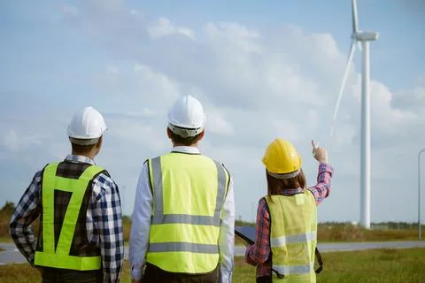 Back view of three engineers discussing and checking turbines on wind turbi.. 写真素材