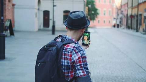 Back view of tourist making video call on smartphone. Video stock 142878566