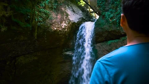 Back view of travel man at waterfall, enjoy nature and beautiful landscape in a Video stock 201180445