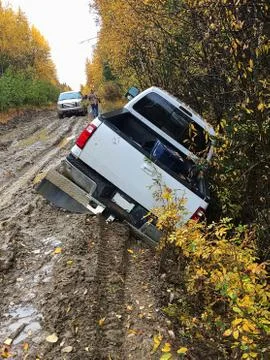 Back view of a truck that has driven off the edge of a muddy road Stock Photos